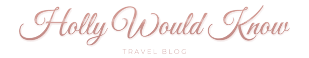 A clean, horizontal logo with "Holly Would Know" in a smooth rose gold cursive and "TRAVEL BLOG" in a minimalist, capitalized sans-serif font below.